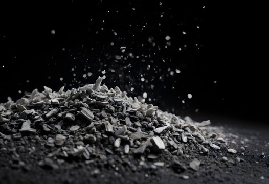 Gray ash and debris scattering over dark background