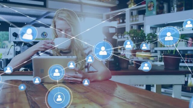 Woman tapping tablet while sipping cup in cafe, blue user icons expanding over scene for marketing