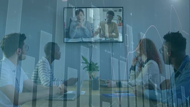 Team watching screen as remote speakers speaking, financial charts overlaying, noting key points