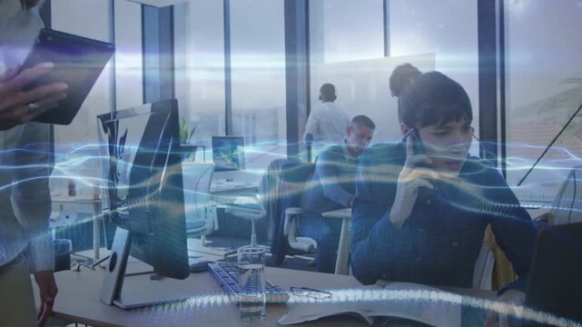 Woman speaking on business call glancing to check peer as tablet passing left, waveform over desks