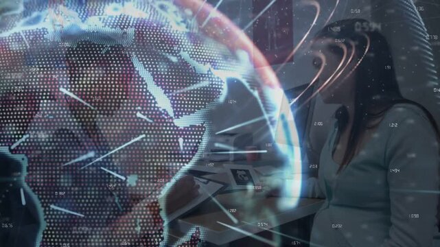 Two women near desk watching holo globe showing data starting shift right and revealing office tech