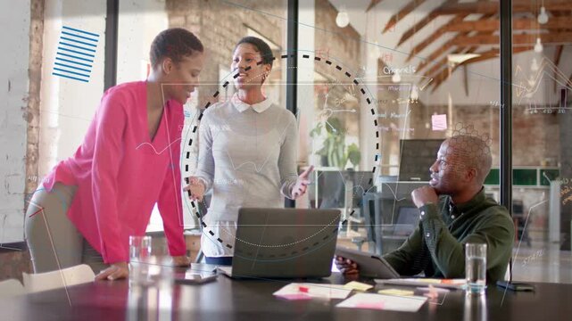Standing speaker starting demo, team leaning on laptop while animated charts appearing for business