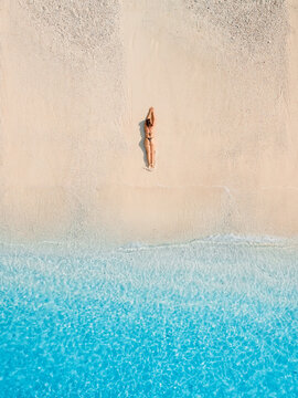 Beauty woman in bikini lying on beach with blue sea