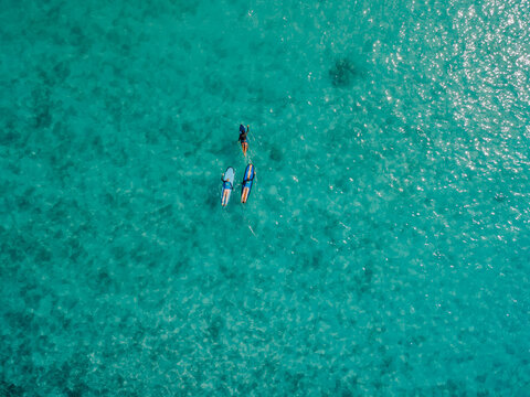 Aerial view of surfers on turquoise ocean in Bali, tropical summer vacation background