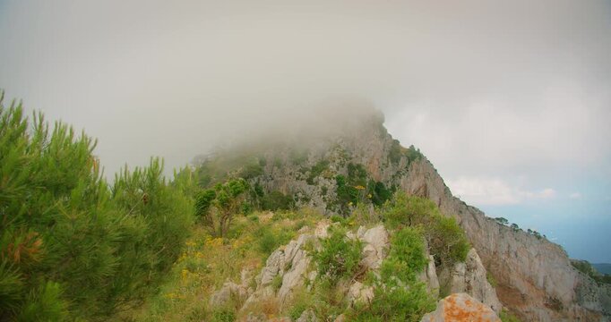 Misty summer scene on Capri island mountain trail to Monte Solaro with rocks and lush green vegetation