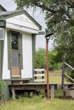Bell near the entrance of a rural home or cabin in a natural setting in the Texas Hill Country outside of Llano, Texas.