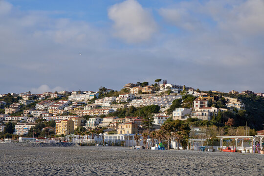 Scenic view of Scalea old town on the hillside from the pebble beach. Mediterranean coastal architecture, traditional houses, and summer resort in Calabria, South Italy.