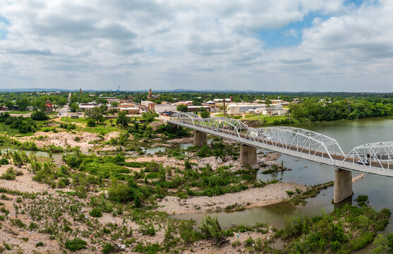 Aerial drone point of view of the Ford Street bridge over the river in Llano, Texas Hill Country with sand bars.