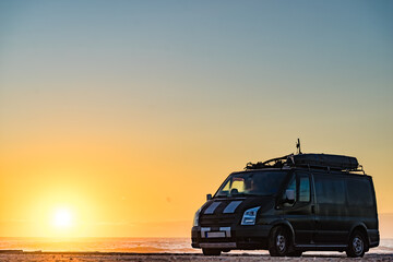 Camper van on beach at sunrise