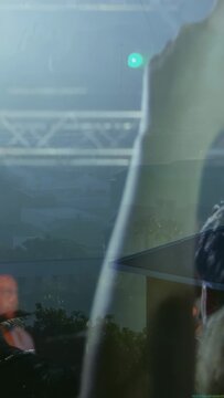 Vertical video: Song starting, phone rising and tilting while bottle passing to record singer