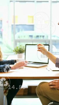 Right man offering pen, woman reaching keys while icons on laptop showing business data for meeting