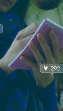Man holding pink notepad and tapping pen, tracking social media metrics animating around pad