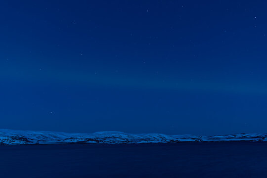 Northern lights with snowcapped mountains view. Finnmark, Norway