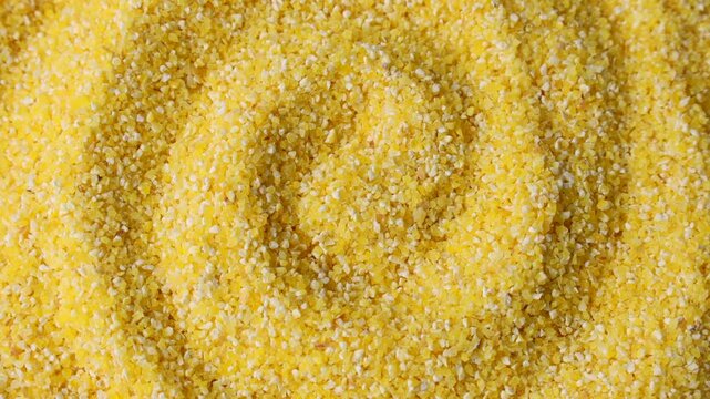 Yellow corn grain flour for polenta porridge circle rotation close up top view