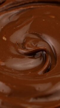 Brown creamy melted milk chocolate spread texture circle rotation close up, vertical video