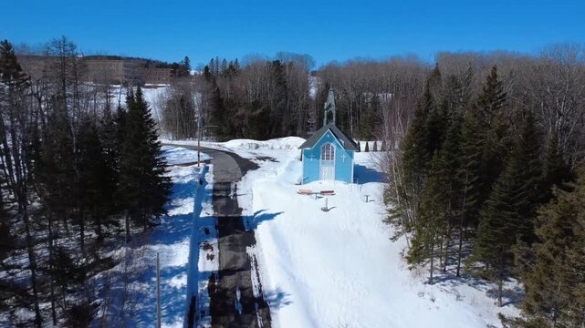 Drone footage approaching the blue facade of Saint Joseph&rsquo;s Oratory in Lac‑au‑Saumon, Quebec. The video highlights the historic bell tower and the village&rsquo;s cultural and religious heritage.
