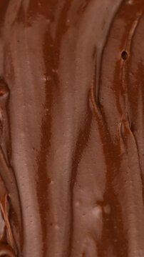 Brown creamy melted milk chocolate spread texture circle rotation close up, vertical video