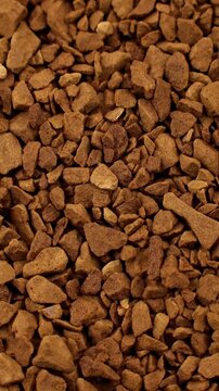 Brown instant freeze-dried coffee texture circle rotation close up, vertical video