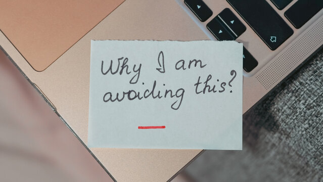 Handwritten note on laptop asking why avoidance is occurring