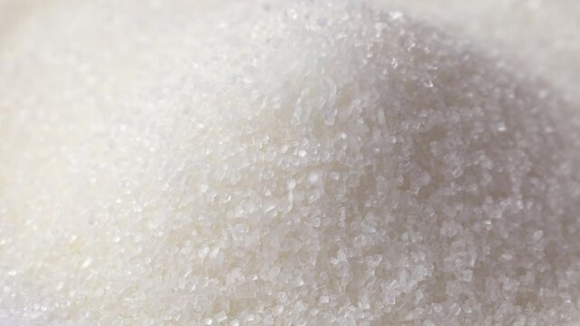 White sugar grains falling down close up