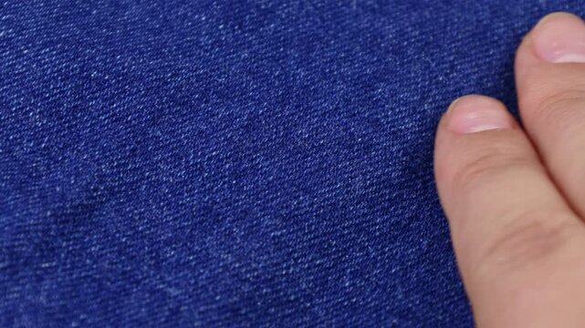 Female hands touching blue natural cotton jeans fabric close up