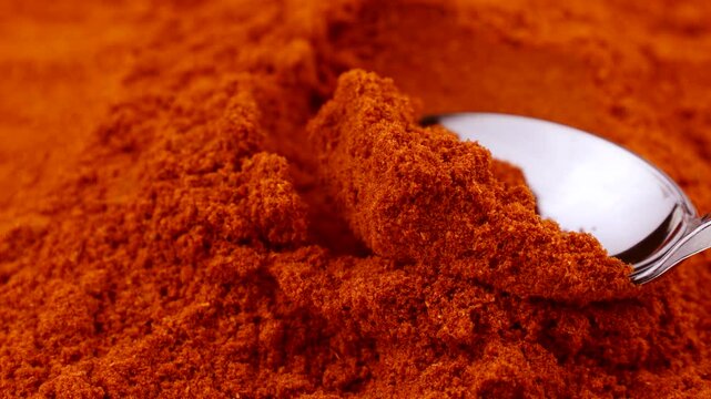 Red smoked paprika powder taking with a spoon close up