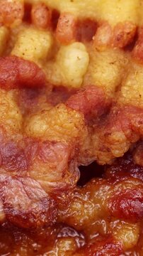Slices of fried bacon circle rotation close up, vertical video format