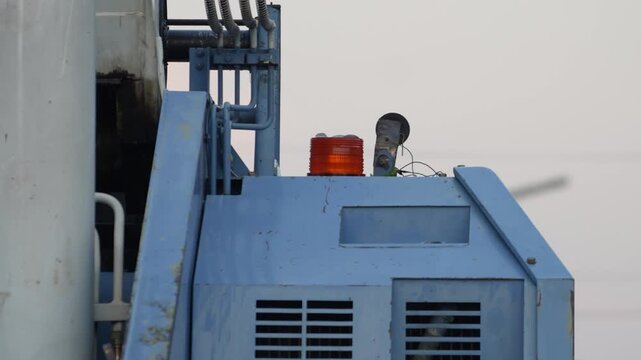 Close-up at flash warning light bulb of construction crane during it operating or lifting heavy object. Safety signal of heavy machine equipment.