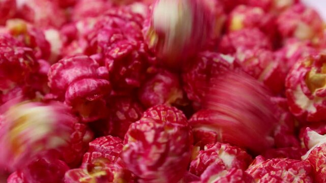 Bright red cherry cinnamon popcorn falling down close up