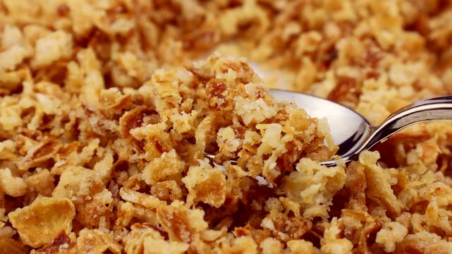 Organic crispy fried onions taking with a spoon close up