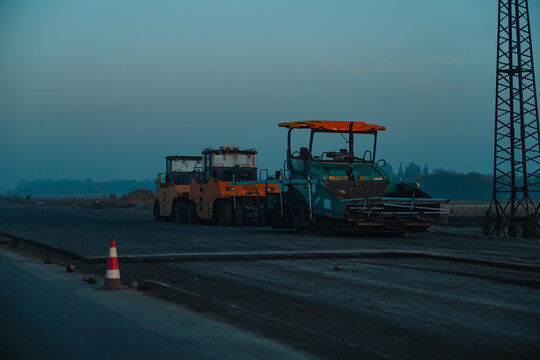 Road construction machinery working at dusk