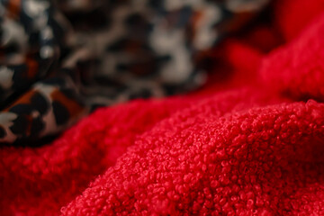 Close up of red teddy fleece fabric with blurred leopard print background. Soft textures © LadyLensArt 