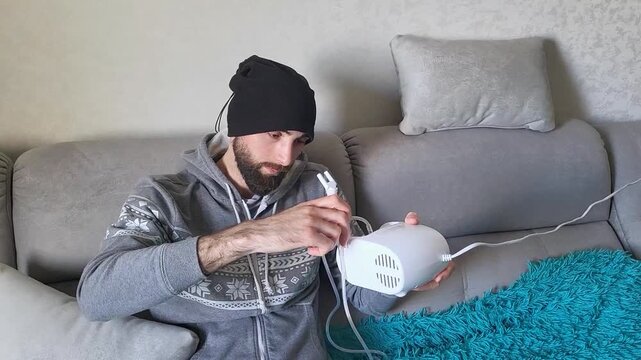 Bearded man administering inhalation therapy for bronchi and throat health at home, medical self-care, respiratory wellness, flu recovery