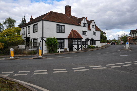 Road intersection on Corbets Tey Road in Havering, with a Tudor‑style building, traffic signs and quiet streets creating a typical suburban scene.