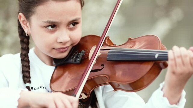 Little Girl Playing Violin in Sunny Summer Park, 4K 10-bit Cinematic Footage.