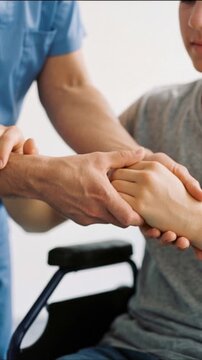 Medical staff massaging and rubbing hands of person with disability, therapeutic rehabilitation concept, vertical video close up.