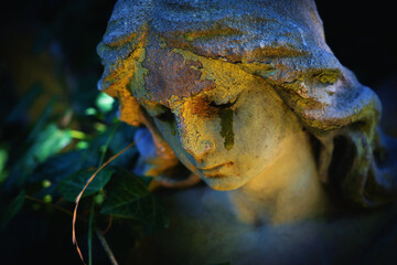 Fototapeta premium Crying angel statue with dark tears, symbol of grief, death and mourning.