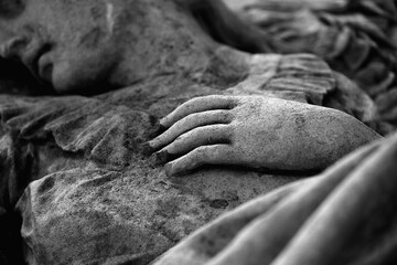 Fototapeta premium Stone angel hand detail in black and white, concept of loss, memory and tender goodbye