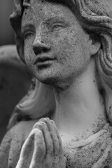 Fototapeta premium Black and white image of angel sculpture in prayer, concept of belief, devotion and inner calm