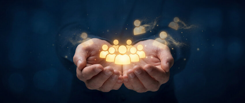 Businessman holding glowing golden human icons with dissolving edges, symbolizing employee turnover, talent retention, digital transition and human resources management challenges in office