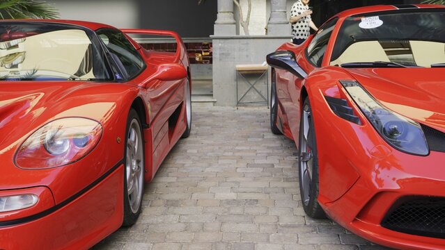 Maspalomas, Las Palmas, Canary Islands, Spain - April 13, 2024 - Two red Ferrari sports cars, F50 and 458 Italia, parked side by side on a brick pavement