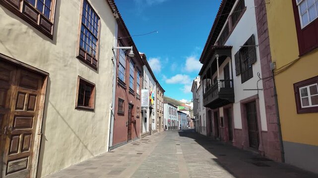 low angle view of a narrow cobblestone street in a historic european town with traditional architecture and colorful colonial buildings