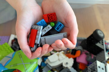 Obraz premium Kid playing with Lego. Assembly bricks or blocks in plastic. Hand visible.