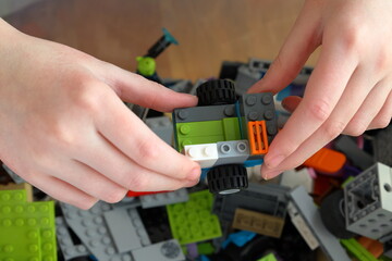 Obraz premium Kid playing with Lego. Assembly bricks or blocks in plastic. Hand visible.