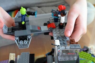 Obraz premium Kid playing with Lego. Assembly bricks or blocks in plastic. Hand visible.