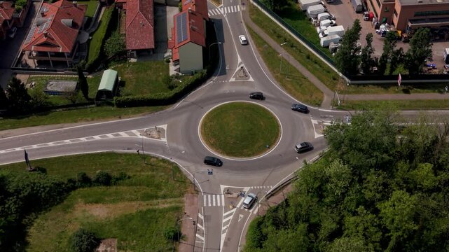 Roundabout Aerial View: An overhead shot captures a bustling roundabout, with vehicles navigating the circular intersection amidst verdant surroundings.