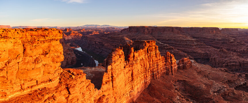 This scenic sunset panorama of Canyonlands National Park features glowing fins and the Colorado River surrounded by breathtaking scenery.