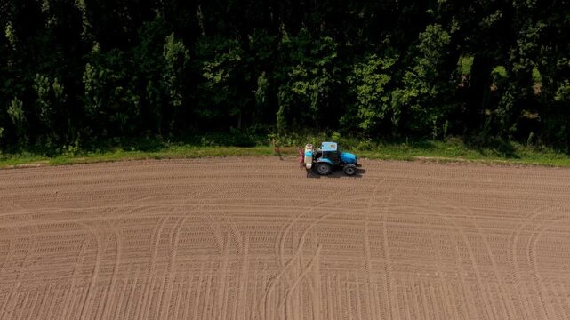 Tractor on Tilled Field: An aerial perspective of a tractor meticulously working the soil, with patterns etched across the land, highlighting the interplay of agriculture and technology.