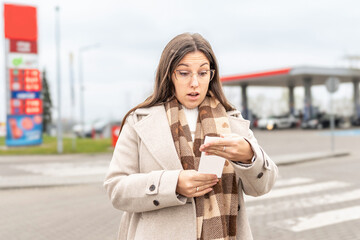 High gas prices woman reading receipt at station © Maksym