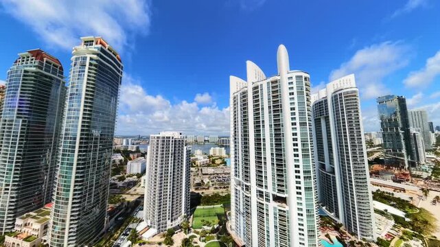 Aerial video tracking highrise buildings drone turns from front view to rear view pull out shot